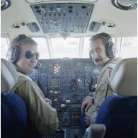 Portrait du pilote et du copilote de l’avion Dassault-Bréguet Gardian devant le tableau de bord de leur appareil au départ à l'aéroport de Moruroa.