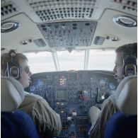 Portrait du pilote et du copilote de l’avion Dassault-Bréguet Gardian devant le tableau de bord de leur appareil au départ à l'aéroport de Moruroa.