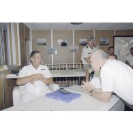 Le général de brigade Michel Boileau, directeur des centres d'expérimentation nucléaire (DIRCEN), discute avec un officier dans la salle de commandement du groupement opérationnel des essais nucléaires (GOEN) pendant le tir nucléaire Aepytos du 27 octobre 1995. En arrière-plan, le colonel Finot, chef de corps de la base interarmées (BIA) de Moruroa.