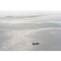 Vue aérienne de la zone de tir et de la barge d’enregistrement et de mesure une heure après le troisième tir souterrain Aepytos du 27 octobre 1995 lors de la dernière campagne d'essais nucléaires dans le lagon de l'atoll de Moruroa.