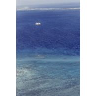Vue aérienne de la zone de tir et de la barge d’enregistrement et de mesure une heure après le troisième tir souterrain Aepytos du 27 octobre 1995 lors de la dernière campagne d'essais nucléaires dans le lagon de l'atoll de Moruroa.