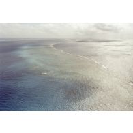 Vue aérienne du platier côté océan une heure après le troisième tir souterrain Aepytos du 27 octobre 1995 lors de la dernière campagne d'essais nucléaires dans le lagon de l'atoll de Moruroa.