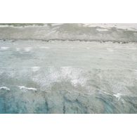Vue aérienne du platier côté océan une heure après le troisième tir souterrain Aepytos du 27 octobre 1995 lors de la dernière campagne d'essais nucléaires dans le lagon de l'atoll de Moruroa.