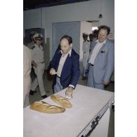 Visite de la boulangerie sur l'atoll de Moruroa. François Bernard, directeur de cabinet civil et militaire du ministre de la défense, et un membre de la délégation goûtent une baguette de pain.