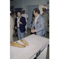 Visite de la boulangerie sur l'atoll de Moruroa. François Bernard, directeur de cabinet civil et militaire du ministre de la défense, et un membre de la délégation goûtent une baguette de pain.