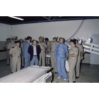 Visite de la boulangerie sur l'atoll de Moruroa. Charles Hernu, ministre de la Défense, écoute un major du 5e régiment mixte du Pacifique (5e RMP) qui explique les installations, en présence de François Bernard, son directeur de cabinet civil et militaire, et du contre-amiral Jacques Choupin, commandant le Centre d'expérimentations du Pacifique (CEP).