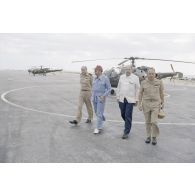 A l'héliport en zone aéroportuaire de l'atoll de Moruroa, Charles Hernu, ministre de la Défense, discute avec le général de corps d’armée aérienne Michel Rouyer, directeur des centres d'expérimentations nucléaires (DIRCEN) et des membres de sa délégation, devant un hélicoptère de reconnaissance Alouette III.