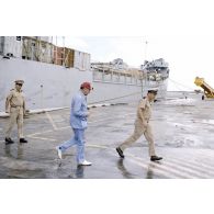 Visite de la zone portuaire sur l'atoll de Moruroa. Charles Hernu, ministre de la Défense, et le général de corps d’armée aérienne Michel Rouyer, directeur des centres d'expérimentations nucléaires (DIRCEN), s'éloignent du bâtiment de débarquement de chars (BDC) Trieux (L9007) et de son commandant le capitaine de corvette Alain Robart, sur le quai.