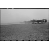 Des bombardiers Heinkel He-111 transformés en avion de transport soulèvent un épais nuage de fumée.