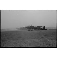 Des bombardiers Heinkel He-111 transformés en avion de transport soulèvent un épais nuage de fumée.