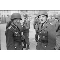 Sur la place de Huelgoat (Finistère centre), des parachutistes allemands de la 3.Fallschirmjäger.Division règlent les derniers détails avant une prise d'armes.