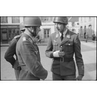 Sur la place de Huelgoat (Finistère centre), des parachutistes allemands de la 3.Fallschirmjäger.Division règlent les derniers détails avant une prise d'armes.