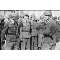 Sur la place de Huelgoat (Finistère centre), des parachutistes allemands de la 3.Fallschirmjäger.Division règlent les derniers détails avant une prise d'armes.