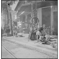 Préparateur de pneumatique dans une rue de Saigon.