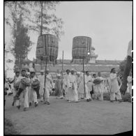 Pham Cong Tac, haut-dignitaire caodaïste, marchant aux côtés de fidèles.