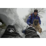 Un maître-chien du PGHM (peloton de gendarmerie de haute montagne) et son chien découvrent une victime sous la neige, lors d'un exercice de recherche après avalanche à Pierrefitte-Nestalas (Hautes-Pyrénées).