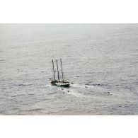 Vue aérienne du navire Rainbow Warrior II de l'association Greenpeace après son arraisonnement escorté par cinq zodiacs, à proximité de l'atoll de Morurua.