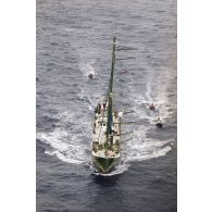 Vue aérienne du navire Rainbow Warrior II de l'association Greenpeace après son arraisonnement escorté par cinq zodiacs, à proximité de l'atoll de Morurua.