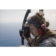 Le maître Fabienne Seynat, photographe de l’ECPA, réalise une prise de vue aérienne à bord d'un hélicoptère.