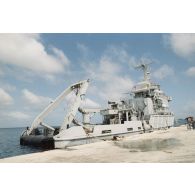 L'adjudant Serge Duponcel, caméraman, et le militaire du rang Emmanuel Ferrat, preneur de son, de l'équipe de tournage de l'ECPA devant le remorqueur-ravitailleur Revi (A635) au port de l'atoll de Moruroa.