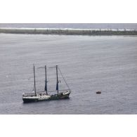 Vue aérienne du navire Rainbow Warrior II de l'association Greenpeace dans le lagon de Fangataufa après le mouillage.