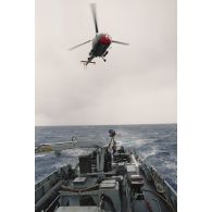 Hélitreuillage avec un plongeur d'un hélicoptère Alouette 3 de l’escadron de transport outre-mer (ETOM) 00/082 sur le patrouilleur La Railleuse (P689) pour l'échange de courrier.
