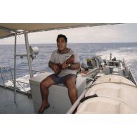 Un matelot polynésien musicien joue du ukulélé à bord du patrouilleur La Railleuse (P689).