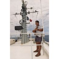 Un matelot polynésien musicien joue du ukulélé à bord du patrouilleur La Railleuse (P689).