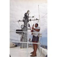 Un matelot polynésien musicien joue du ukulélé à bord du patrouilleur La Railleuse (P689).