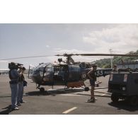Le caméraman Drouillet et le preneur de son de Frédéric de Ravignan de l'équipe de tournage de l’ECPA en action devant l'hélicoptère  Alouette 3 de l’escadrille 12S à l'aéroport de la base aérienne (BA) 190 de Faa'a-Papeete.