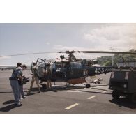 Le caméraman Drouillet et le preneur de son de Frédéric de Ravignan de l'équipe de tournage de l’ECPA en action devant l'hélicoptère  Alouette 3 de l’escadrille 12S à l'aéroport de la base aérienne (BA) 190 de Faa'a-Papeete.