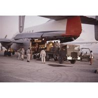 Déchargement d'un avion de transport Bréguet Deux Ponts transportant du fret pour le centre d'expérimentations du Pacifique (CEP) à l'aéroport d'un atoll de Polynésie française.