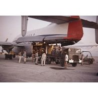 Déchargement d'un avion de transport Bréguet Deux Ponts transportant du fret pour le centre d'expérimentations du Pacifique (CEP) à l'aéroport d'un atoll de Polynésie française.