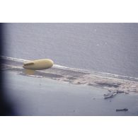 Vue aérienne du ballon captif gonflé à l'hélium à 520 m d'altitude supportant la nacelle du premier engin français à fusion nucléaire dit bombe H lors du tir Canopus au-dessus du lagon de l'atoll de Fangataufa le 24 août 1968.