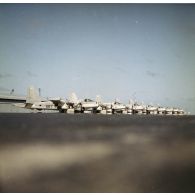 Alignement de huit avions de patrouille maritime Neptune au parking probablement de l'aéroport de la base avancée du CEP sur l'atoll d'Hao.