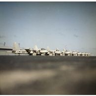 Alignement de huit avions de patrouille maritime Neptune au parking probablement de l'aéroport de la base avancée du CEP sur l'atoll d'Hao.