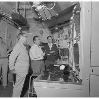 H5. Visite des installations à bord du croiseur de commandement De Grasse par Michel Debré, ministre de la Défense, lors du tir Licorne du 3 juillet 1970, avec les explications données par Robert Camelin, directeur des essais.