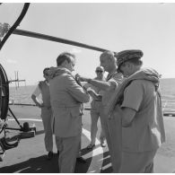 Michel Debré, ministre de la Défense, s'équipe d'un gilet de sauvetage avant son départ du croiseur De Grasse en hélicoptère Alouette III pour une visite des sites après l'explosion du tir Licorne à Moruroa (Mururoa) le 3 juillet 1970.