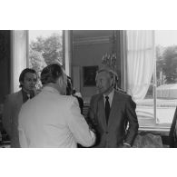 Charles Hernu, ministre de la Défense, entouré de membres de son cabinet, reçoit en audience une délégation d'élus de la Polynésie française conduite par Gaston Flosse qu'il salue.