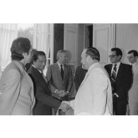 Charles Hernu, ministre de la Défense, entouré de membres de son cabinet, reçoit en audience une délégation d'élus de la Polynésie française conduite par Gaston Flosse. Il salue un élu polynésien.