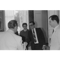 Charles Hernu, ministre de la Défense, entouré de membres de son cabinet, reçoit en audience une délégation d'élus de la Polynésie française, dont Jacques Teuira qu'il salue.