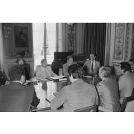 Charles Hernu, ministre de la Défense, entouré de membres de son cabinet, reçoit en audience une délégation d'élus de la Polynésie française conduite par Gaston Flosse (de dos).