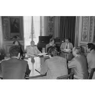 Charles Hernu, ministre de la Défense, entouré de membres de son cabinet, reçoit en audience une délégation d'élus de la Polynésie française conduite par Gaston Flosse (de dos).