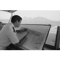 Sortie en mer du patrouilleur La Combattante P730 pour une course de pirogues à l'île de Moorea. Le point sur la carte marine en vue de Moorea.