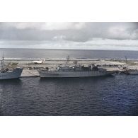 Vue aérienne des bâtiments de soutien logistique (BSL) Rance (A618), spécialisé dans la sécurité radiologique, et Tarn (A 771) à quai sur l'atoll de Moruroa. Un avion Breguet Deux Ponts stationne à l'aéroport.