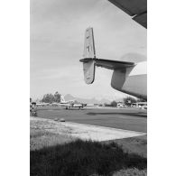 Avion Piper PA-23 Aztec du groupe aérien mixte (GAM) 82 stationné derrière un avion Breguet Deux-Ponts (inscription "Louis Bréguet" sur l'empennage) à l'aéroport de Tahiti-Faa'a. En arrière-plan, la station météo et l'île de Moorea.