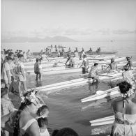 Fêtes du Juillet ou fête du Tiurai à Papeete en 1964. Course de pirogues. En arrière-plan, l'île de Moorea.