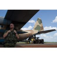 Un soldat espagnol encadre le chargement de fret à bord d'un avion Hercules C-130 par un chariot Manitou du détachement de transit interarmées (DéTIA) sur l'aéroport de Bamako-Sénou, au Mali.