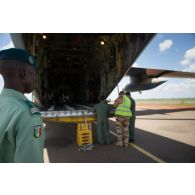 Un soldat du détachement de transit interarmées (DéTIA) échange avec des convoyeurs espagnols pour le chargement de matériel à bord d'un avion hercules C-130 sur l'aéroport de Bamako-Sénou, au Mali.