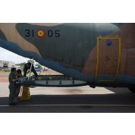 Un soldat du détachement de transit interarmées (DéTIA) échange avec des convoyeurs espagnols pour le chargement de matériel à bord d'un avion hercules C-130 sur l'aéroport de Bamako-Sénou, au Mali.